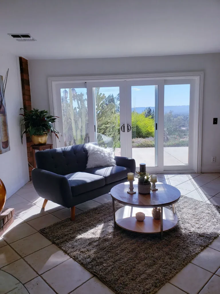 Sitting area with a navy sofa and round coffee table by French doors