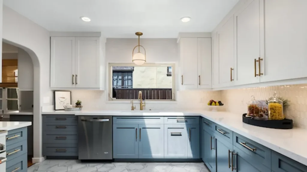 Kitchen with white uppers, navy lowers, gold pulls and an arched doorway