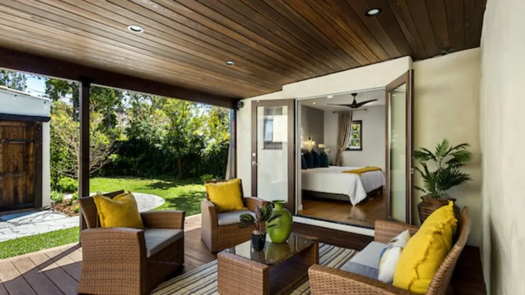 Covered patio with wicker seating looking into a staged bedroom
