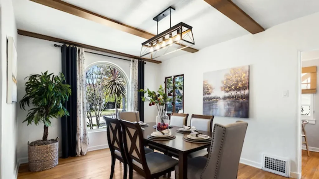 Dining room with a wood table, an arched window and a linear chandelier