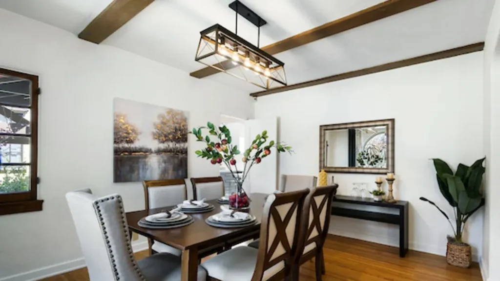 Dining room with a dark wood table, gray chairs and a linear chandelier