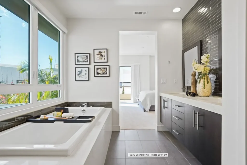Bathroom with a soaking tub, dark wood vanity and floor-to-ceiling windows