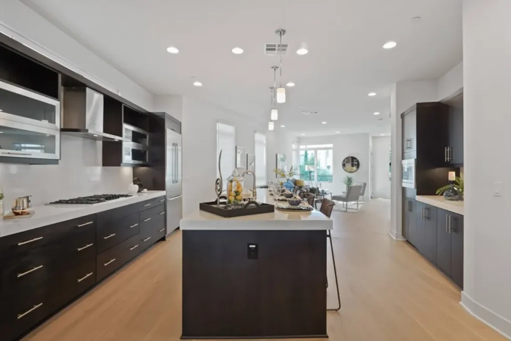Kitchen with dark wood cabinets, a white counter island and pendant lights