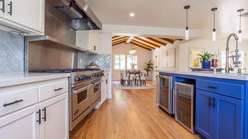 Kitchen with white cabinets, a bright blue island and a professional range