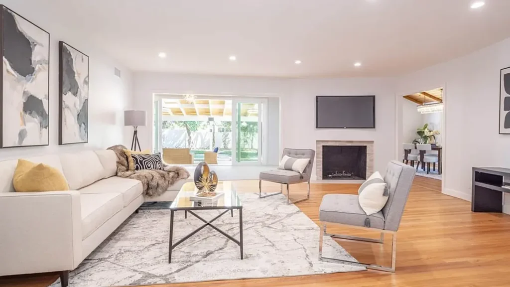 Living room with a white sofa, gray accent chairs and a fireplace
