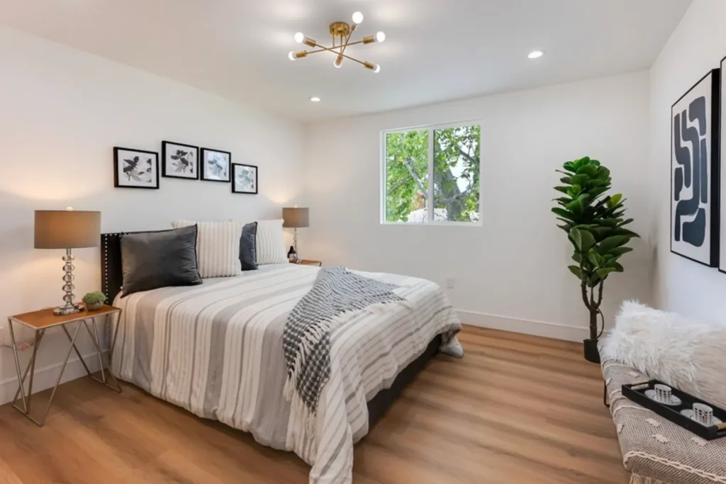 Bedroom with striped bedding, a black headboard and a framed gallery wall