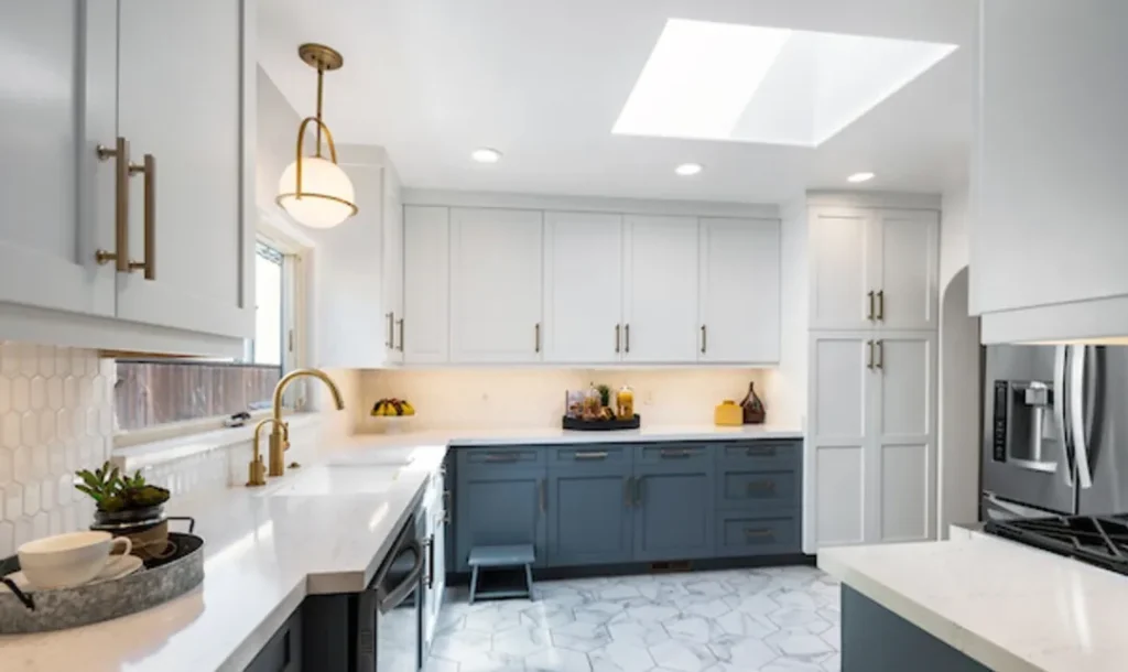 Kitchen with white and navy cabinets, a skylight and a white farmhouse sink